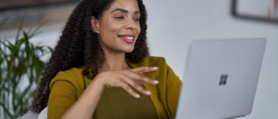 A women smiling while looking at a laptop