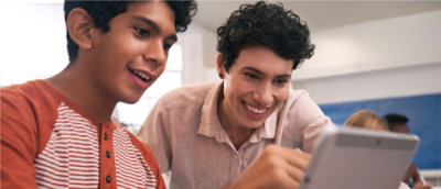 A couple of young men looking at a computer screen.