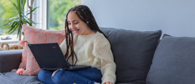 A person sitting on a couch using a computer.