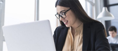 A person in glasses looking at a computer