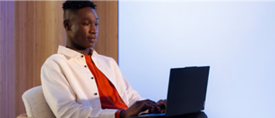 A man in a white shirt using a laptop.