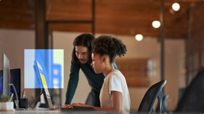A man and woman looking at a laptop.