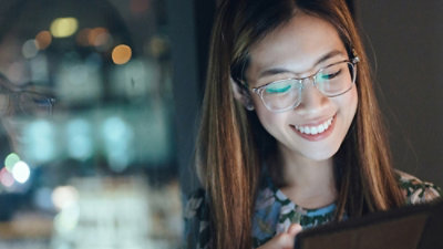 A woman looking at her phone and smiling
