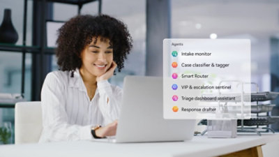 A woman smiling at a laptop