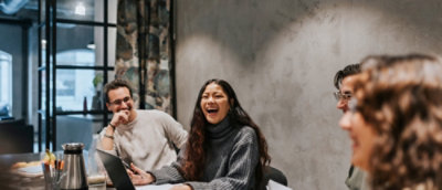 Group collaborating and laughing at a work table