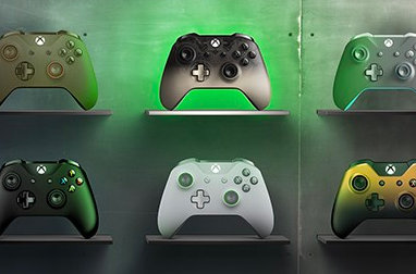Six Xbox controllers in various colors and designs displayed on shelves