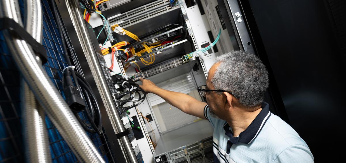 man works on server in cabinet