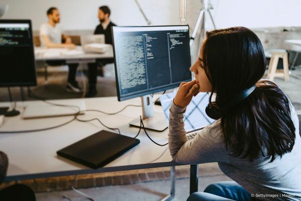 A woman sitting behind a computer screen