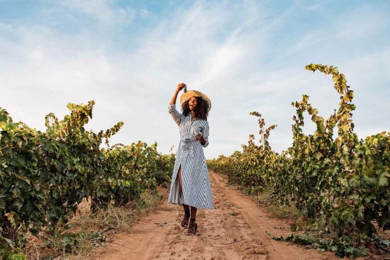 woman walking among vineyards on wine tour in spain.