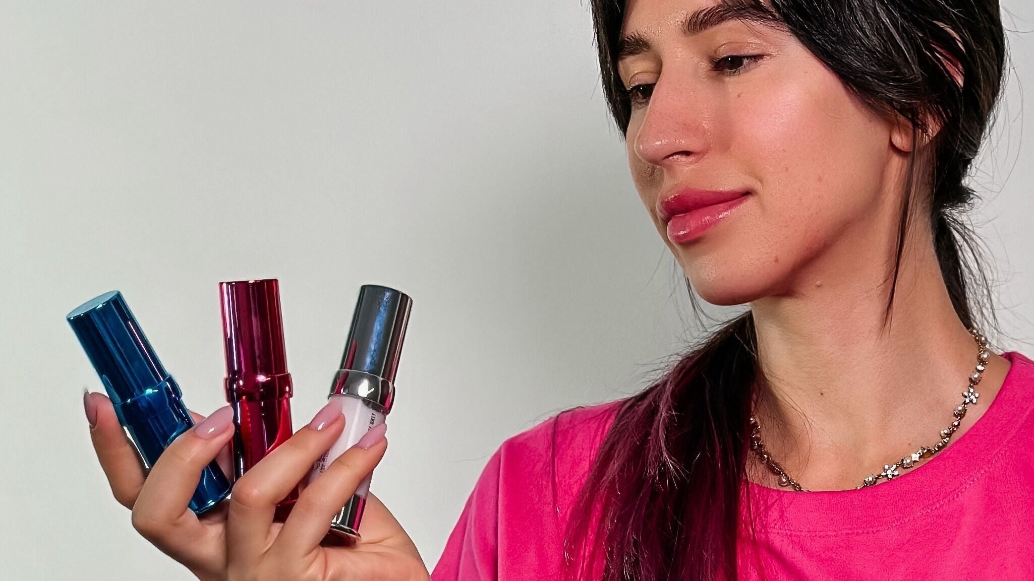 Woman holding vibrant lipsticks at Browow: Brows & Lips That Stay in Melbourne, Victoria, AU.