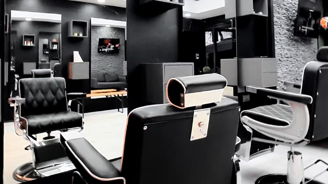 Modern interior of Teo Barbershop, London, England, GB featuring sleek black styling chairs.
