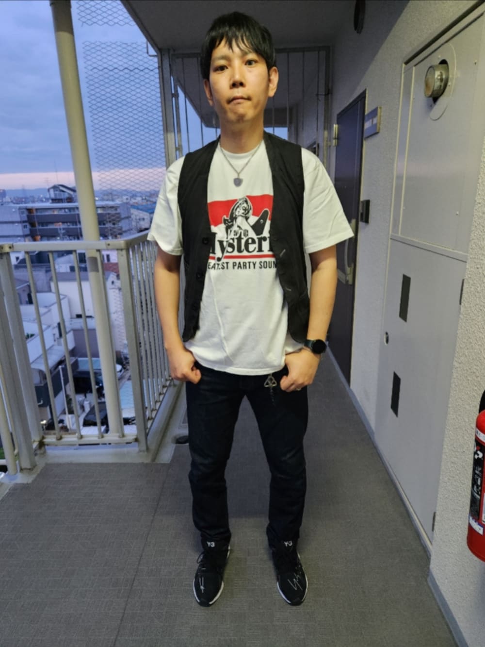 ブラック系のベスト、ホワイト系のTシャツ/カットソー、ブルー系のデニムパンツを着用したメンズの春コーディネートの3枚目の写真