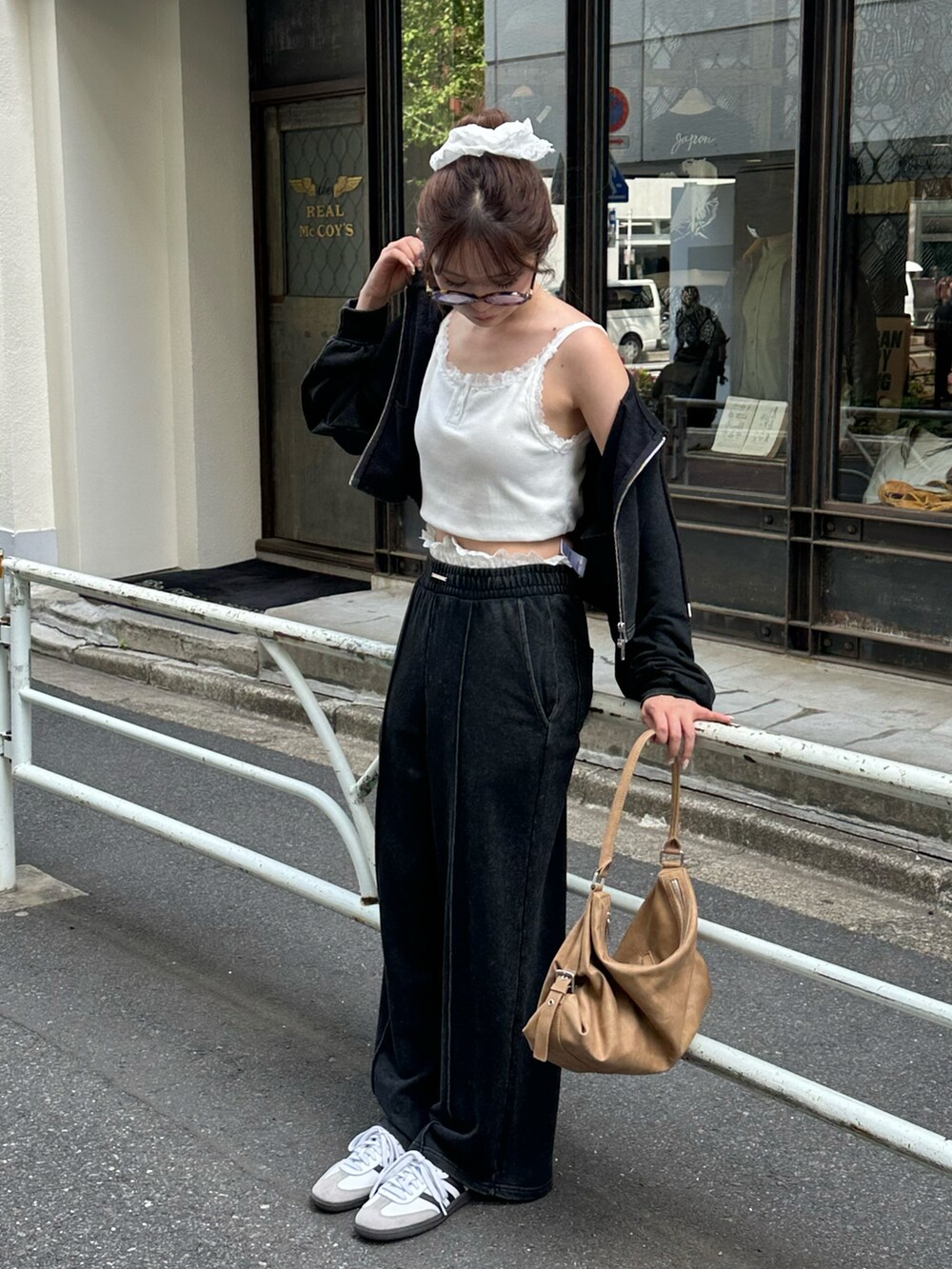 ブラック系のスウェットパンツ、ブラック系のパーカー、ブラウン系のバッグを着用したレディースの春コーディネートの4枚目の写真