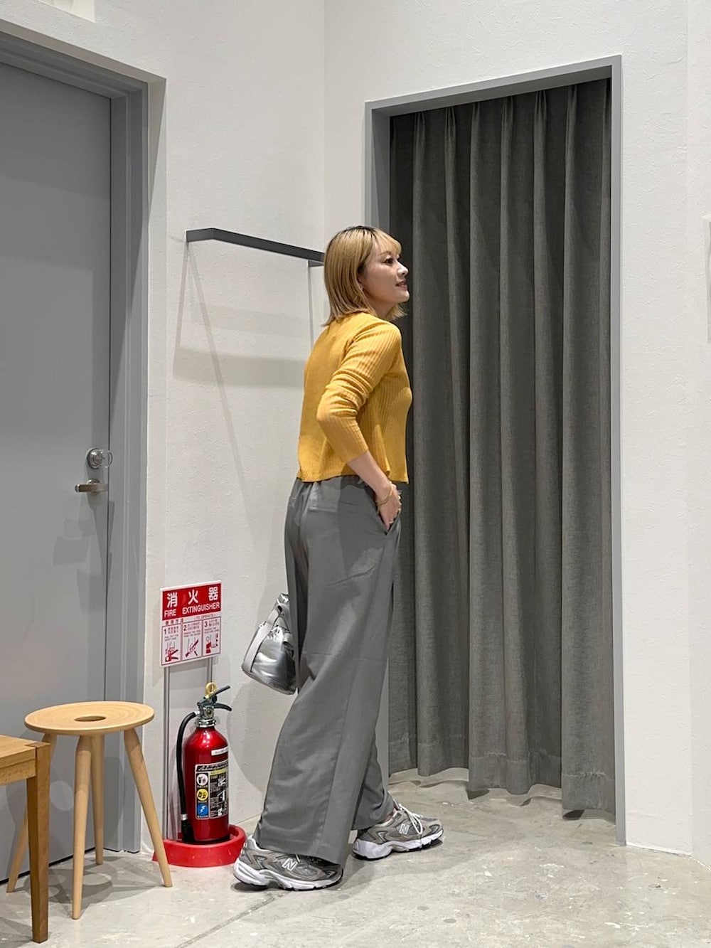 グレー系のその他パンツ、シルバー系のショルダーバッグ、イエロー系のカーディガン/ボレロを着用したレディースの秋コーディネートの2枚目の写真