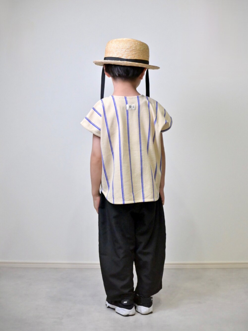 ブルー系のシャツ/ブラウス、ブラック系のその他パンツ、ブラック系のスニーカーを着用したキッズの春コーディネートの2枚目の写真