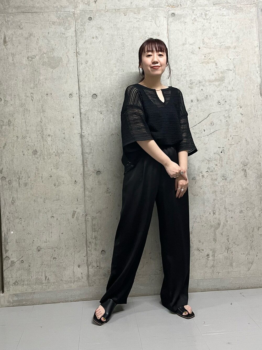 ブラック系のシャツ/ブラウス、ブラック系のサンダル、ゴールド系のネックレスを着用したレディースの春コーディネートの4枚目の写真