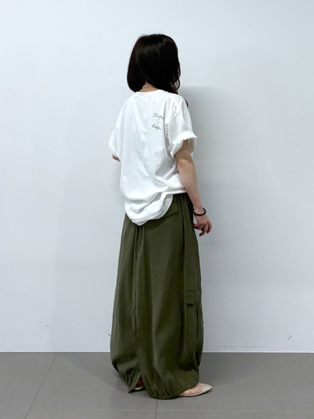 ベージュ系のパンプス、グリーン系のスカート、ホワイト系のTシャツ/カットソーを着用したレディースの春コーディネートの2枚目の写真