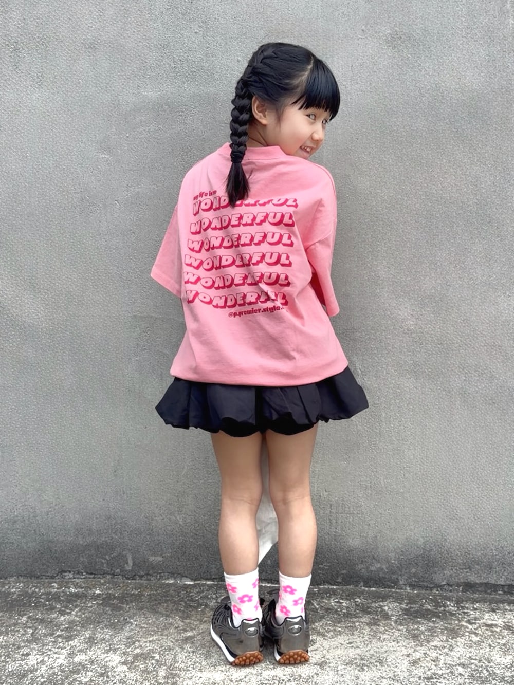 ピンク系のTシャツ/カットソー、ホワイト系のトートバッグ、ブラック系のスカートを着用したキッズの春コーディネートの5枚目の写真