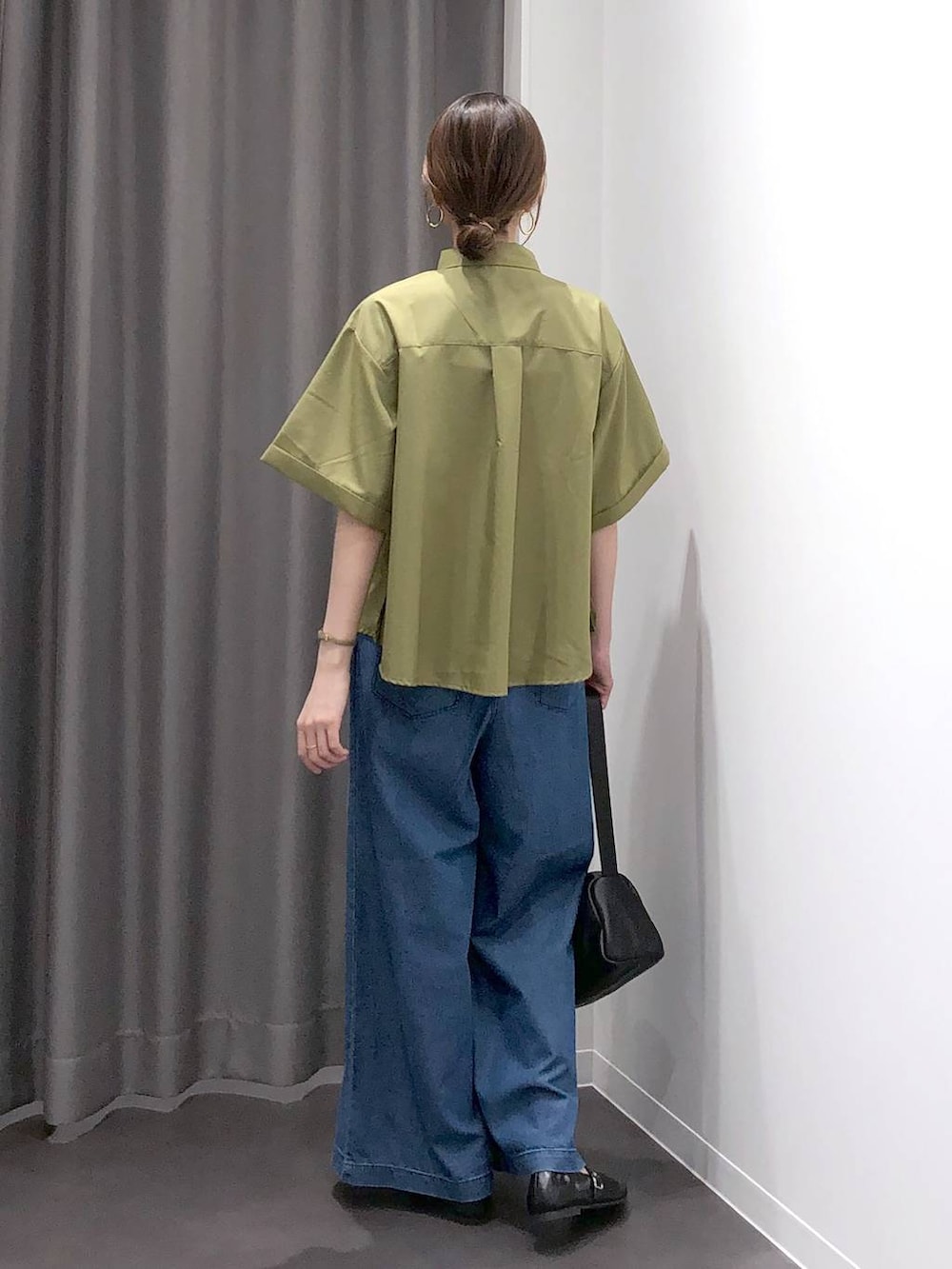 ブラック系のパンプス、ブラック系のショルダーバッグ、グリーン系のシャツ/ブラウスを着用したレディースの夏コーディネートの4枚目の写真