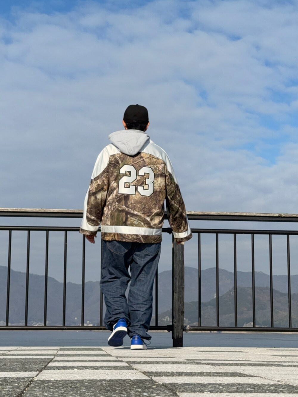 ブルー系のデニムパンツ、ブルー系のスニーカー、ブラウン系のTシャツ/カットソーを着用したメンズの冬コーディネートの3枚目の写真