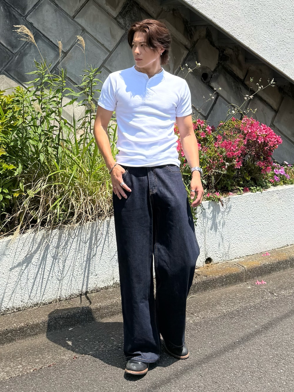 ホワイト系のTシャツ/カットソー、ブルー系のデニムパンツ、ブラック系のブーツを着用したメンズの春コーディネートの2枚目の写真