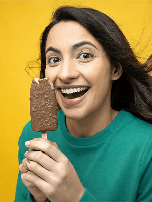 Woman holding orange slice, representing tooth enamel protection