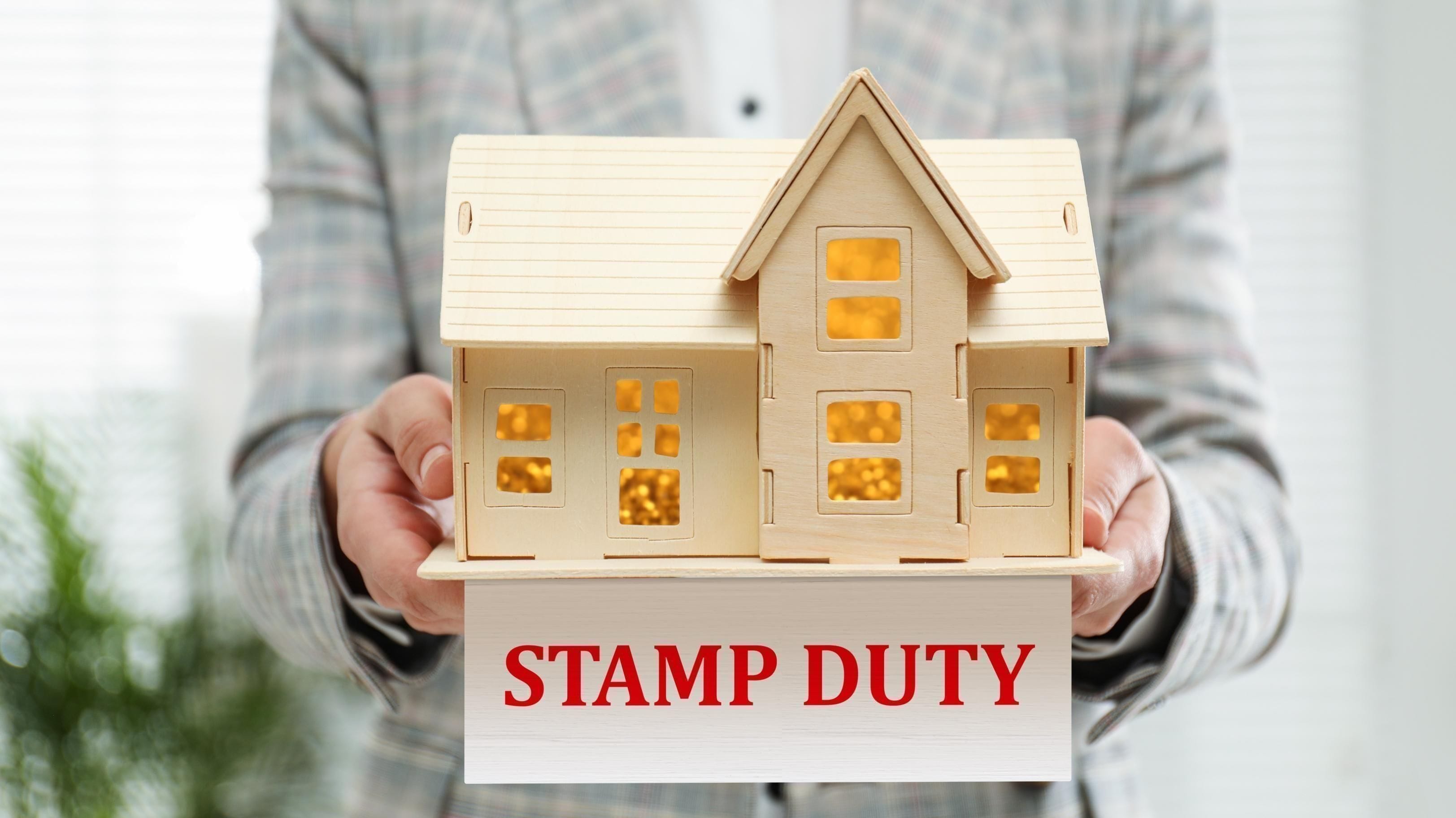 A man holding a home model and stamp duty written below