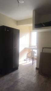 The balcony features a railing, a potted plant, buildings, and trees at Media Apartments, Sector 7 Dwarka, New Delhi
