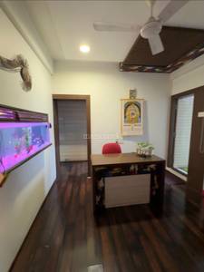 The living room contains a red sofa and wooden floor