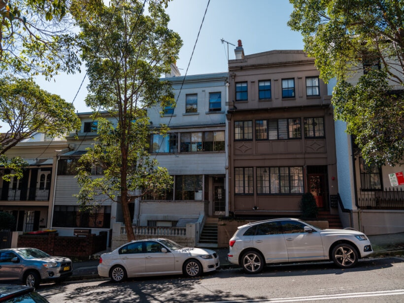 Terraces on street with cars and gates visible