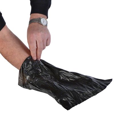 Ruka navlači crnu plastičnu vrećicu na ruku, prikazuje upotrebu proizvoda.