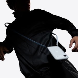 iPhoneを取りつけたクロスボディストラップを装着した人物の胴部