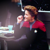usuallyhats: Janeway sitting at a table, smiling (janeway)