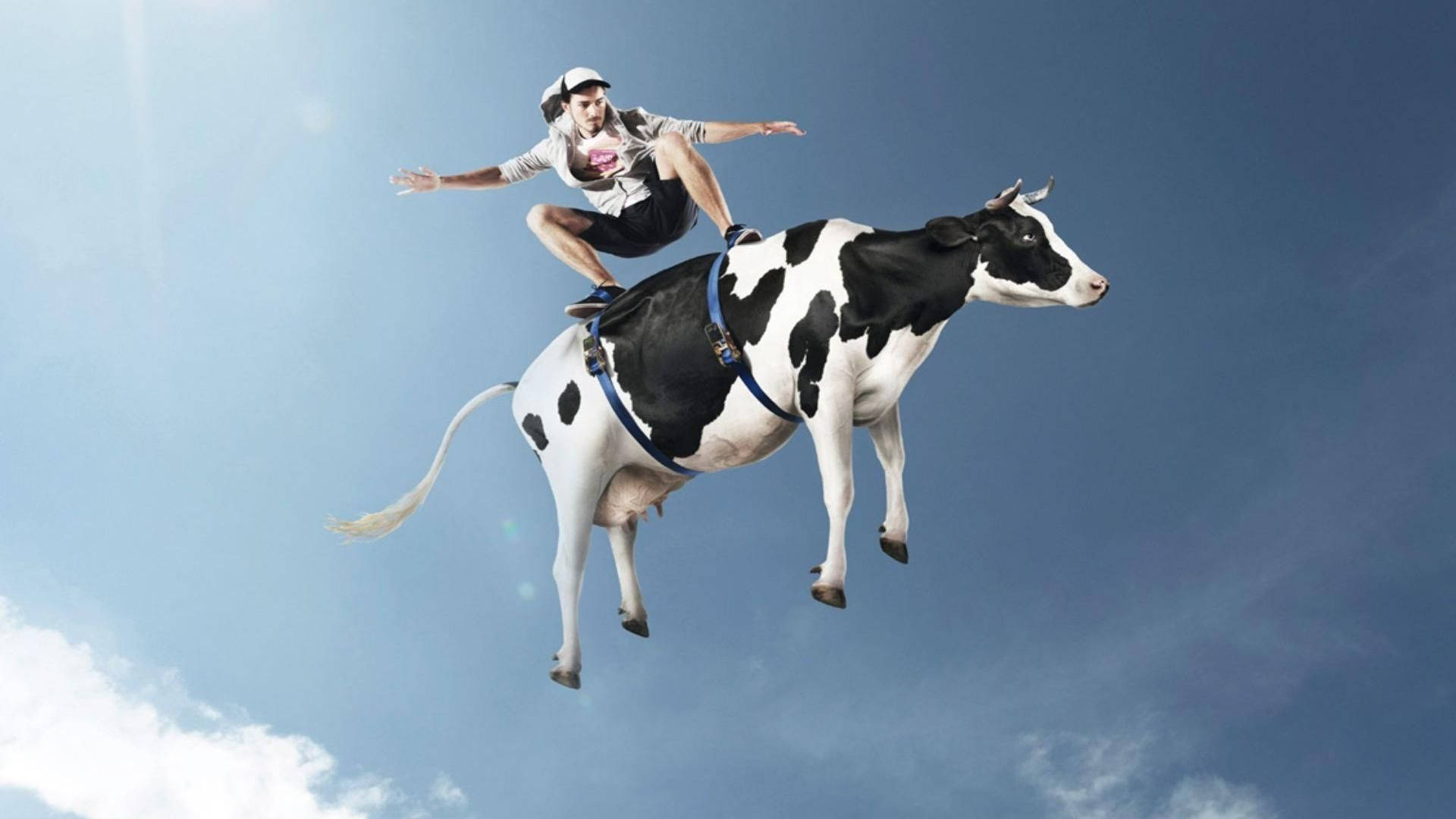 A person riding a flying cow against a blue sky with clouds.