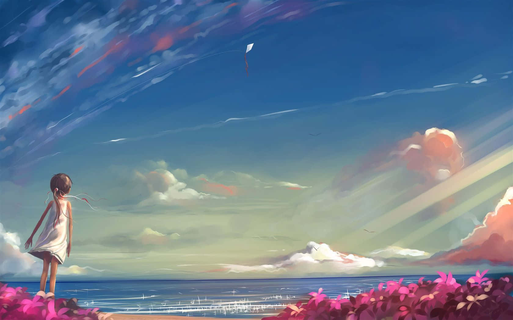 A girl in a white dress stands on a beach with pink flowers watching a kite fly over the ocean. — Dreams Wallpaper