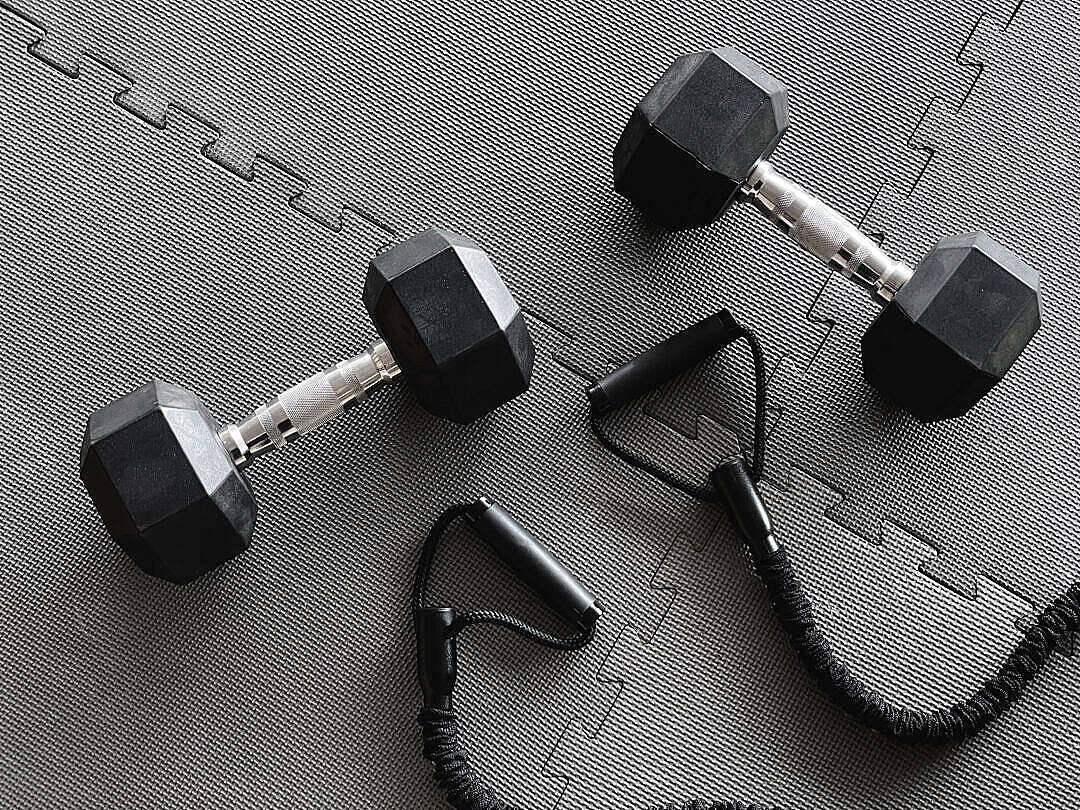 Haltères noirs et bande de résistance sur tapis de gym gris. — Motivation de Gym Fonds d'écran