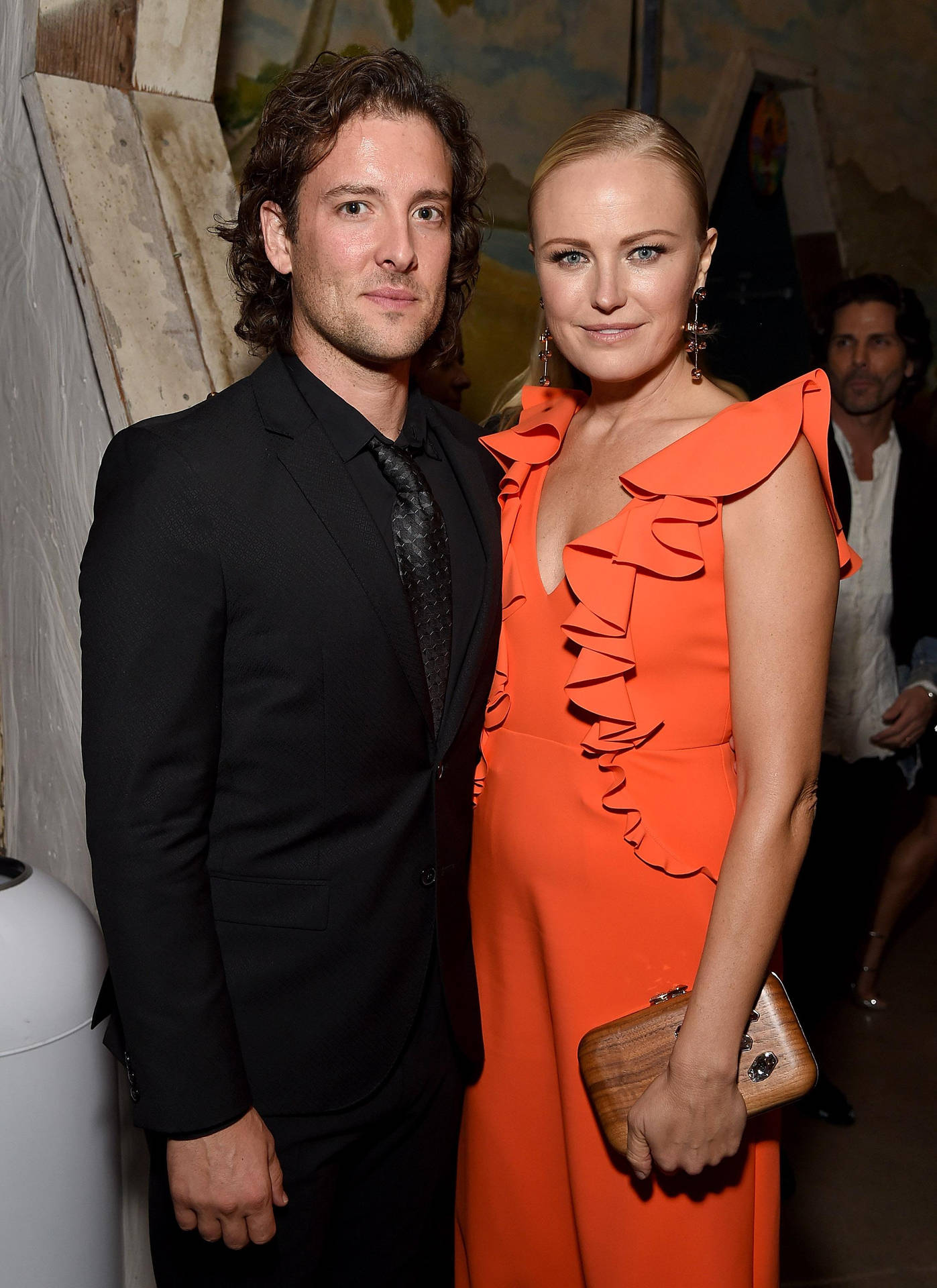 Une superbe photo de l'actrice Malin Akerman et de son partenaire lors d'un événement sur le tapis rouge portant des robes orange et souriant apparemment à la caméra. — Actrice Fonds d'écran