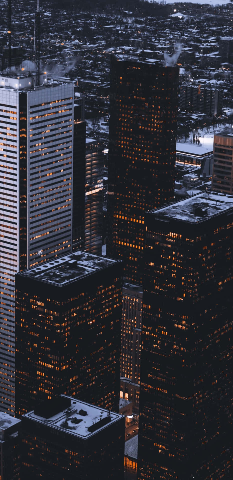 Snow-covered city skyline at night with illuminated windows