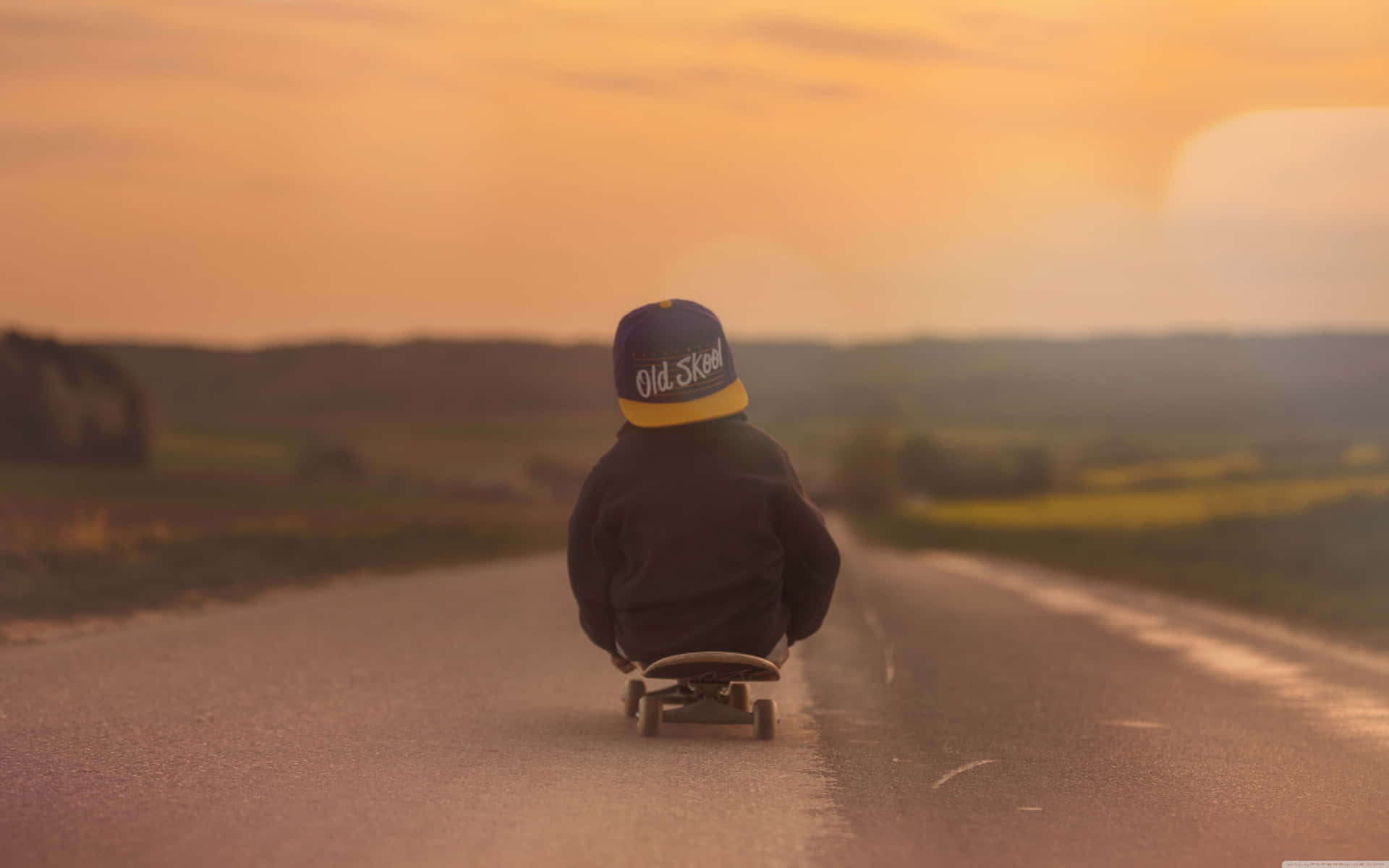 Ummenino Está Andando De Skate Por Uma Estrada Ao Pôr Do Sol. Papel de Parede