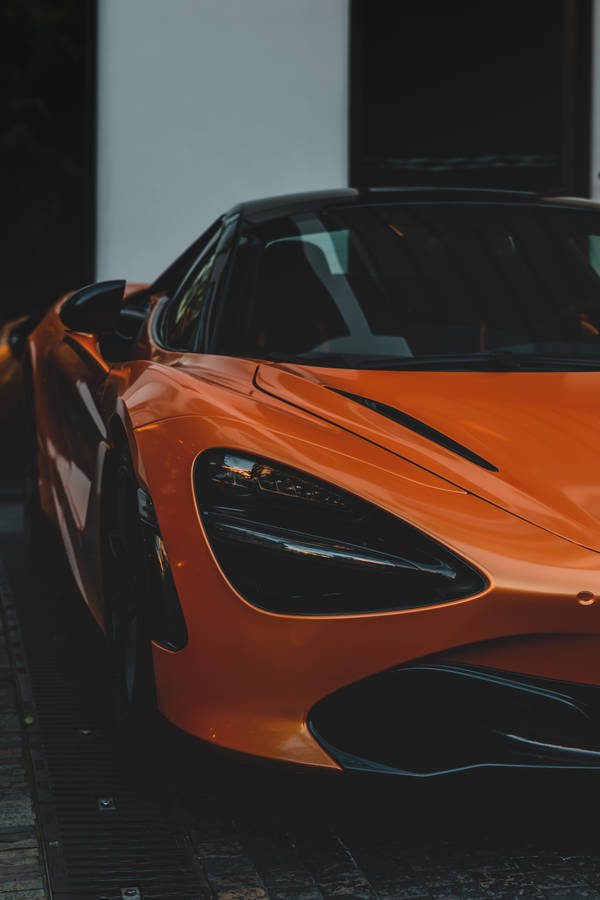 Wallpaper van een oranje sportauto in halve weergave close-up opname.