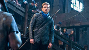 Young archer in snowy wooden arena with spectators watching.