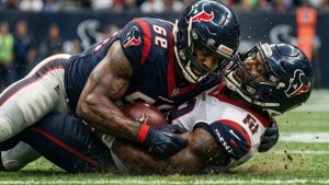 Jogador defensivo dos Texans fazendo um tackle.