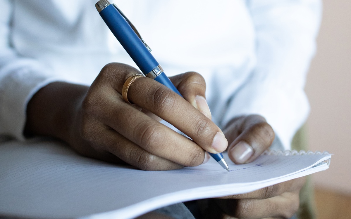 Photos of a person writing on a notepad 