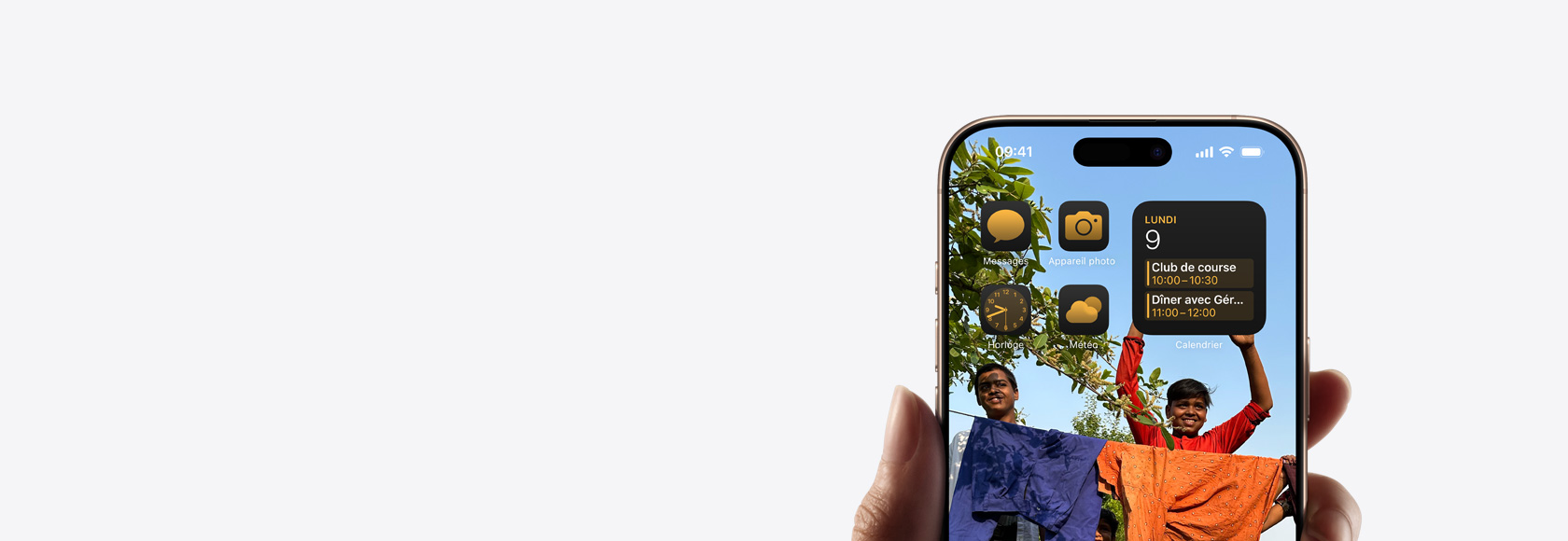 Main tenant un iPhone 16 Pro dont l’écran d’accueil, des icônes et des widgets sont visibles.
