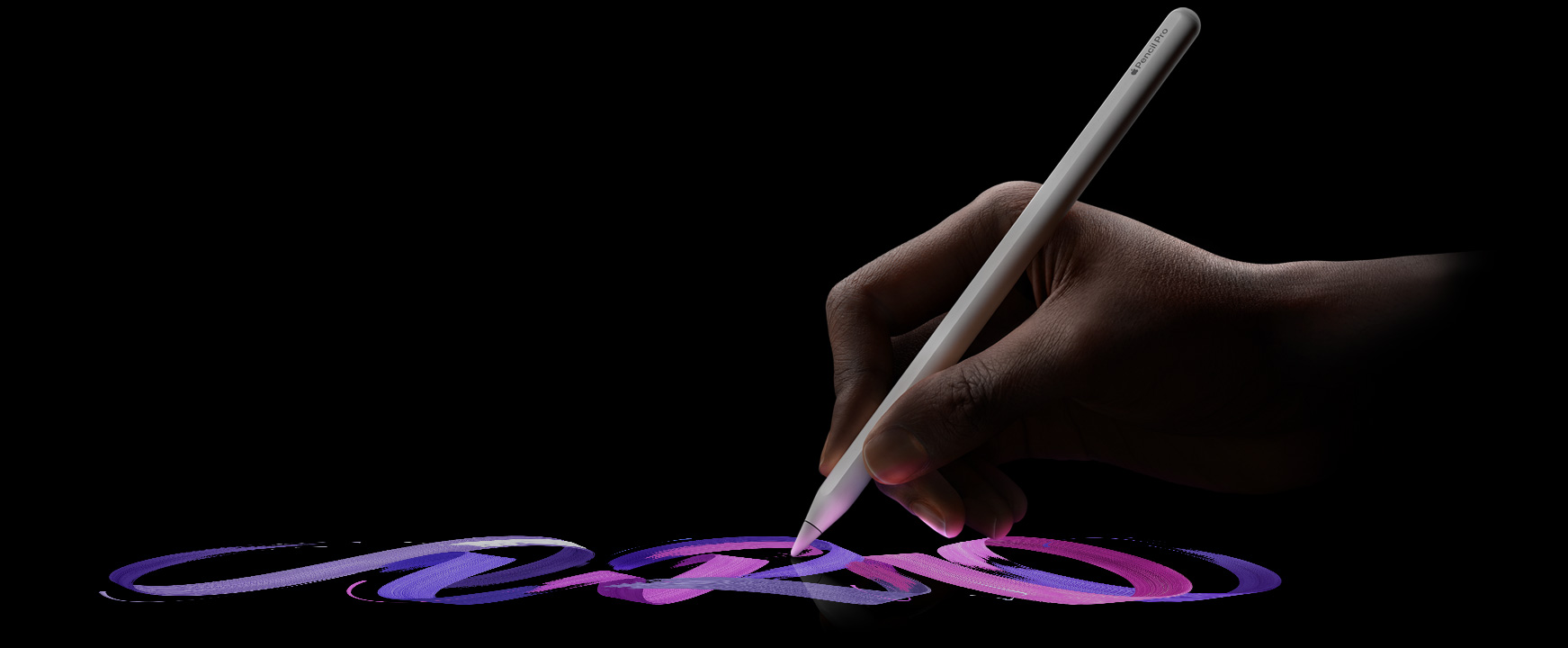 Lietotājs tur Apple Pencil Pro un ar otu uzvelk košu līniju