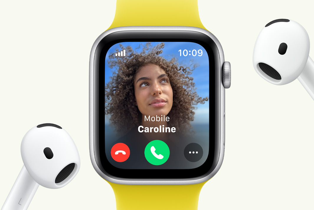 Apple Watch SE s prikazom dolaznog poziva pokraj para slušalica AirPods