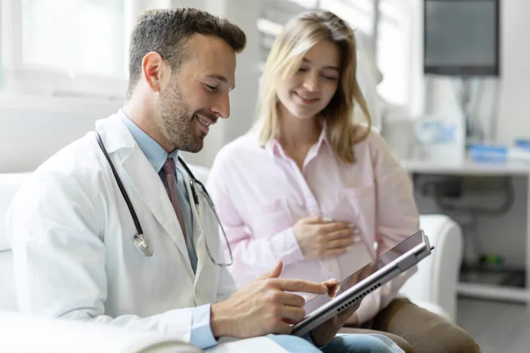 Doctor and woman looking at a tablet in a doctor's office