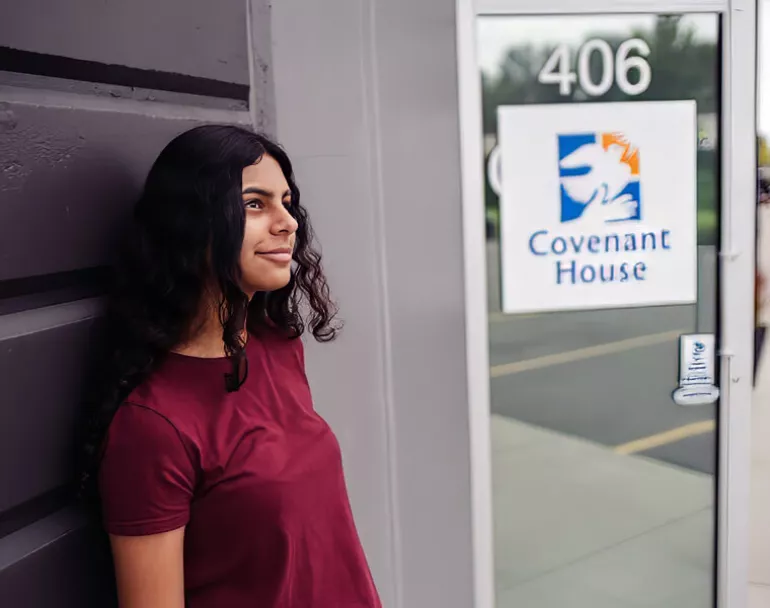 Young previously homeless girl leaning on Covenant House