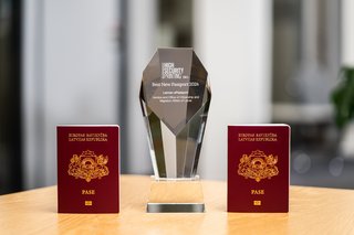 Two frontally photographed Latvian passports with Veridos Award in between