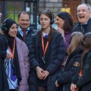 Minister for Business Richard Lochhead (right) joins pupils and staff from Holy Rood High School as they are entertained by Mercat Tours Storyteller Nicola Hamilton during A Day in Edinburgh.